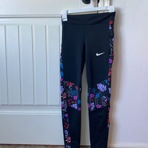 Black Nike leggings in a girls large with flower designs on the sides and knees